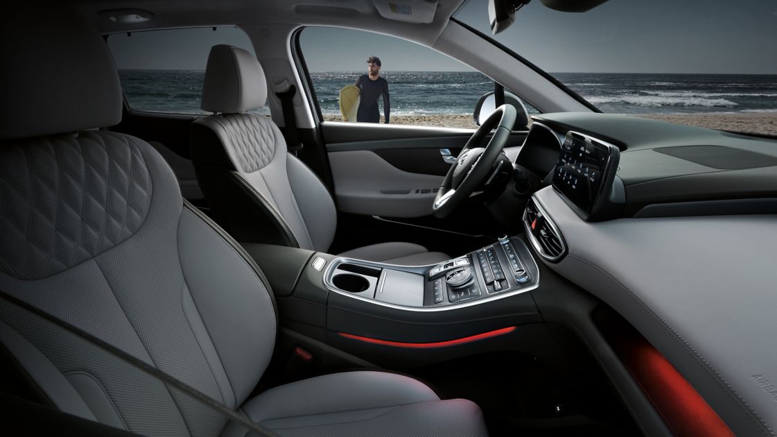 Pohled do prostoru předních sedadel v interiéru nového sedmimístného SUV Hyundai Santa Fe Hybrid. 
